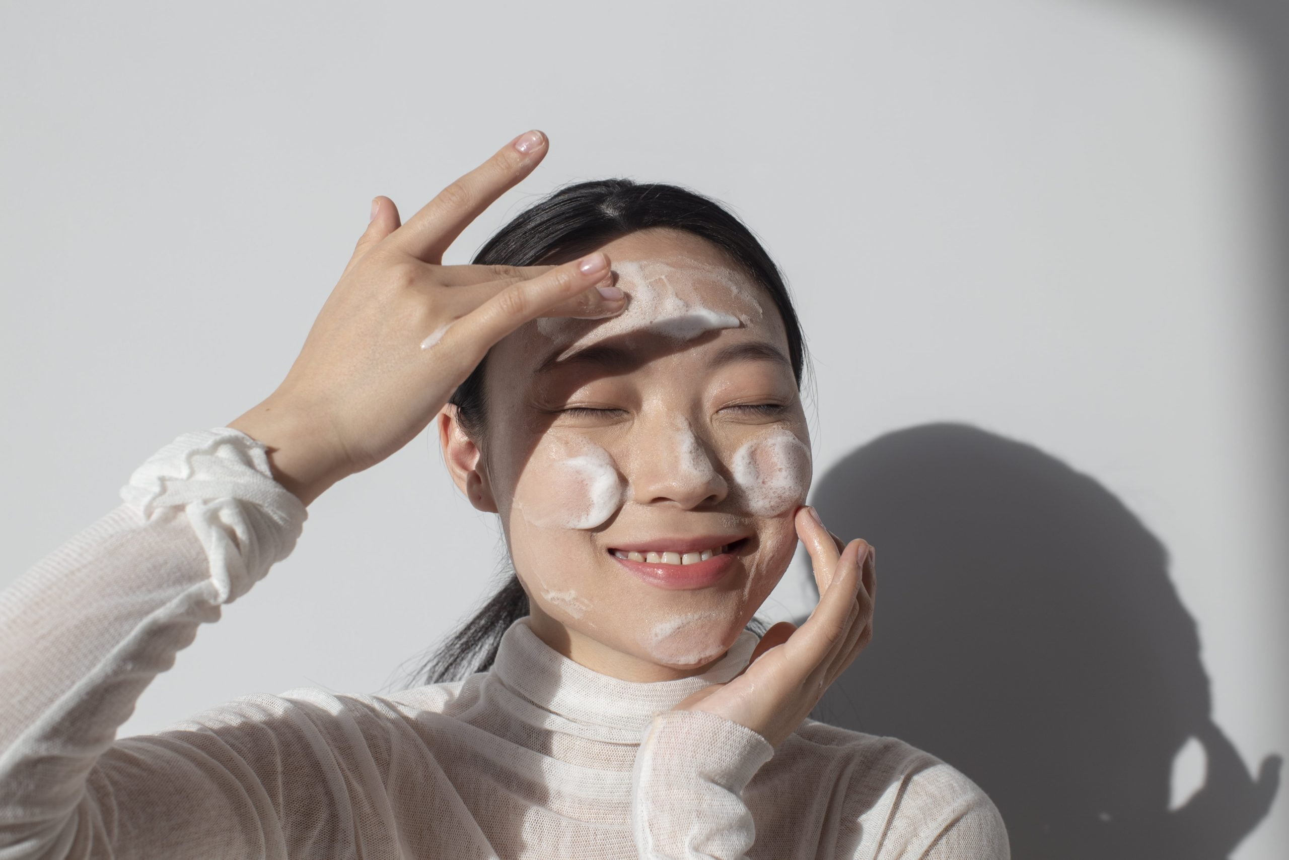 Seorang perempuan asia sedang melakukan facial wash